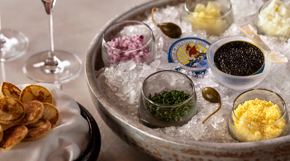 Various small glass bowls of caviar served on ice