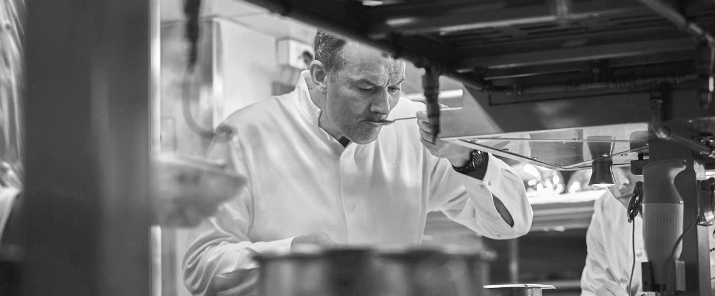 Chef Lesquer tests a dish in his kitchen