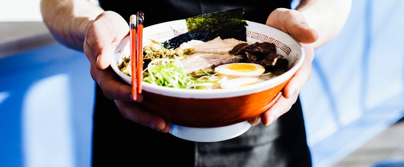 Man holds ramen bowl in Japan
