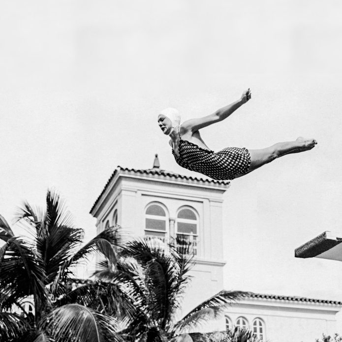An old photo of a woman diving off a diving board