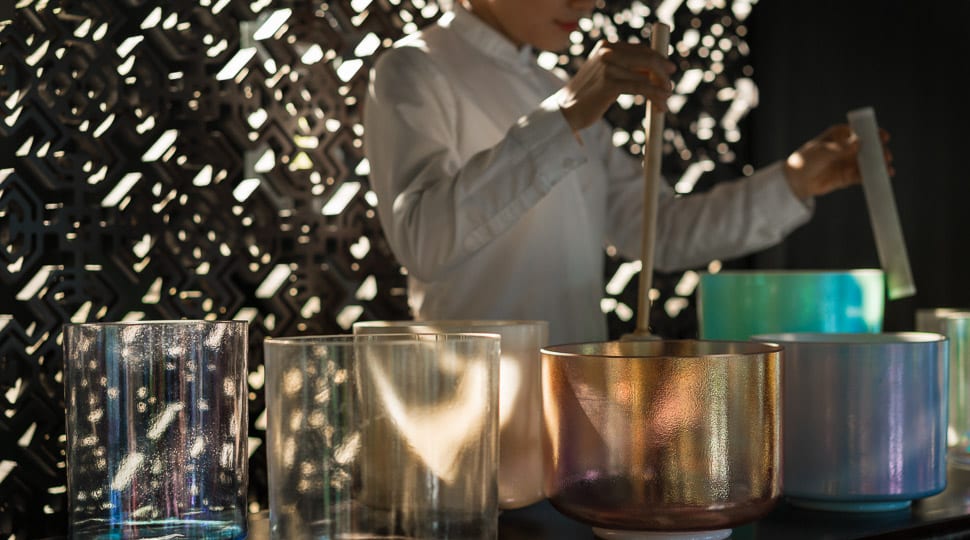 Quartz bowls arranged on table, person standing behind