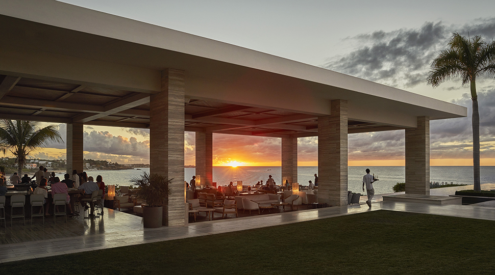 Sunset Lounge poolside bar and dining area at sunset, silhouette of palm tree