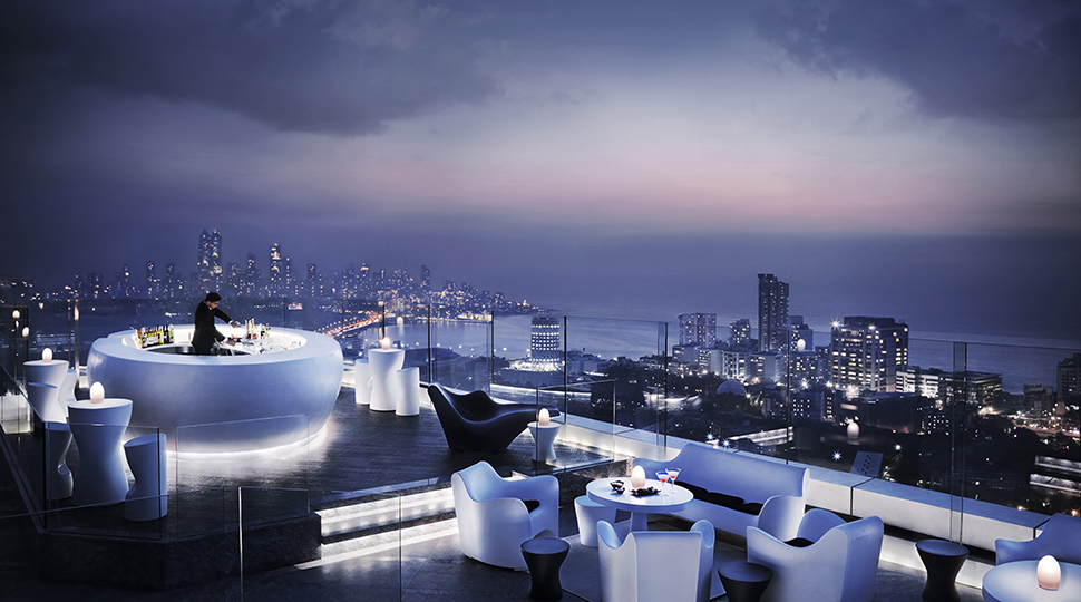 Bartender mixes drink in glowing white circular bar on rooftop lounge, modern chairs and tables