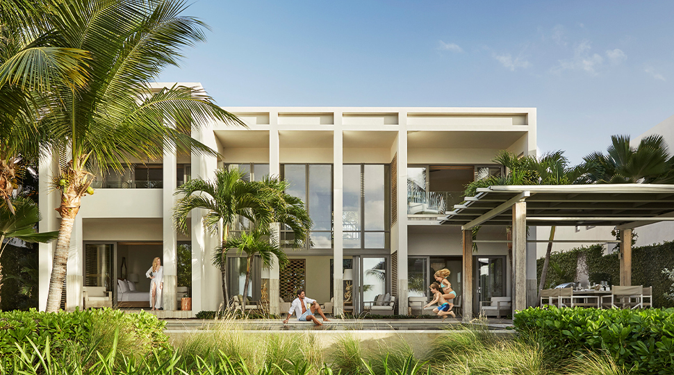Two-storey white stucco residence surrounded by tropical greenery
