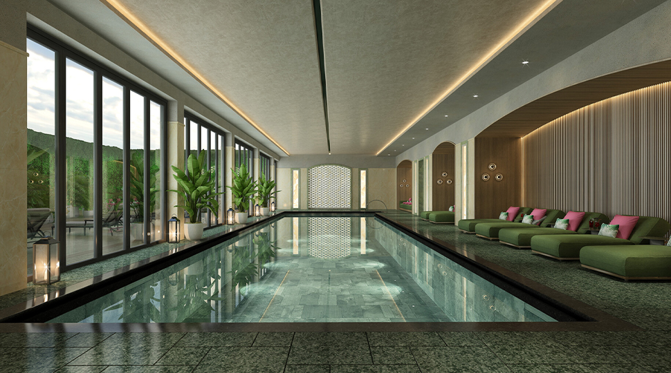 Indoor pool with lounge chairs on one side and floor-to-ceiling windows on the other