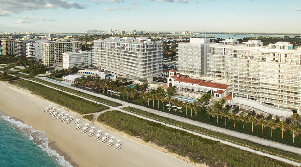 Aerial view of three white buildings lining the beach