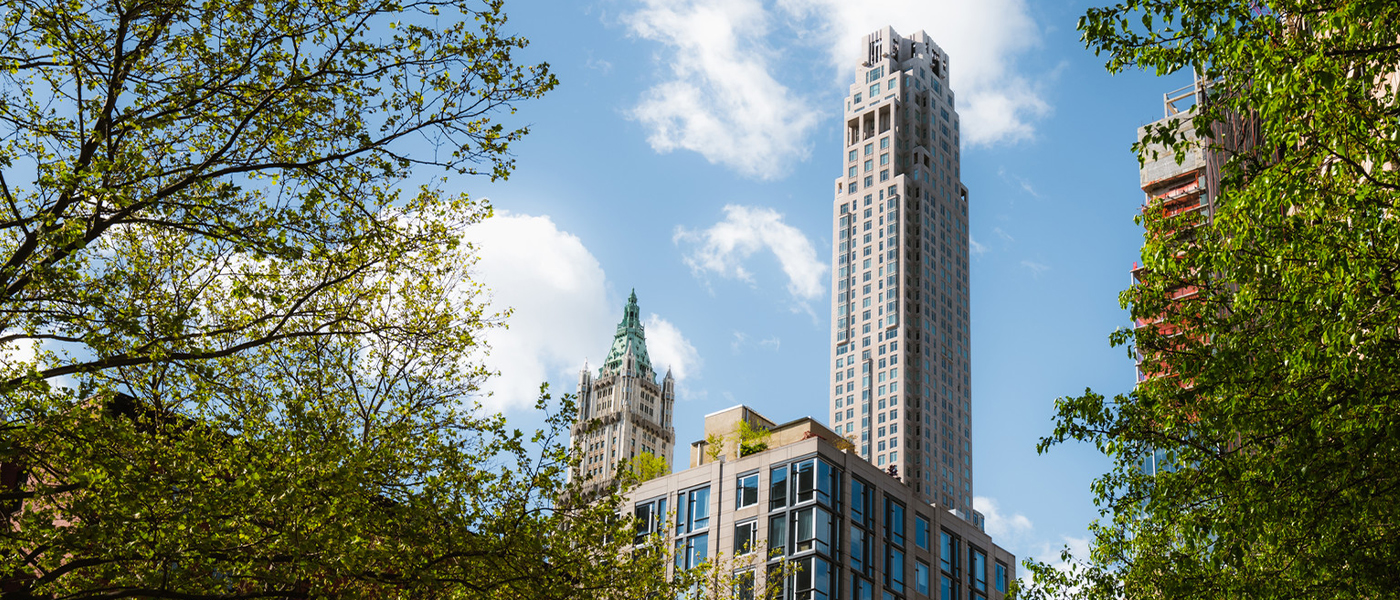 View of downtown New York skyscraper and buildings framed by trees in the summer