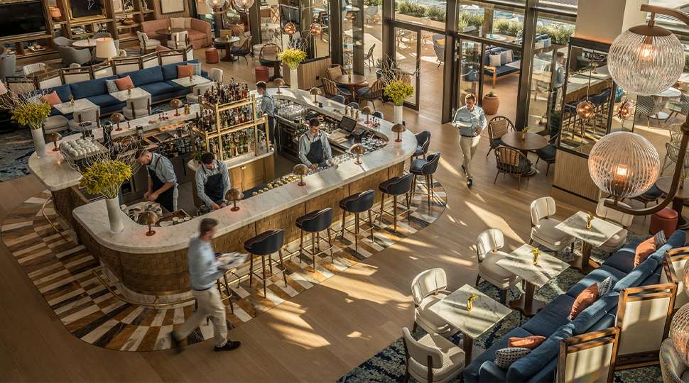 Overhead view of Avra bar in Athens featuring a large centre bar, lounge area and multiple dining tables