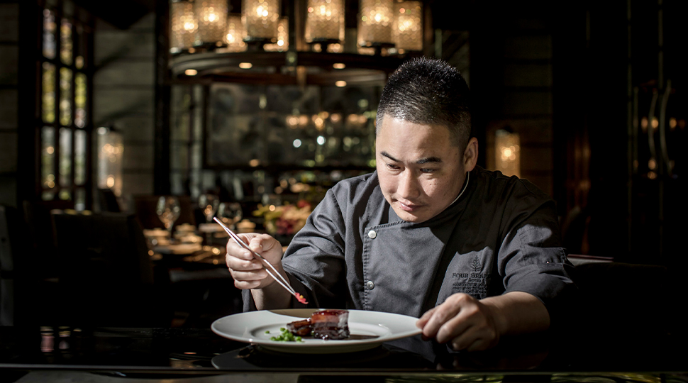 Executive Chinese Chef Wang Yong places the final garnish on a dish in the dining room of Jin Sha