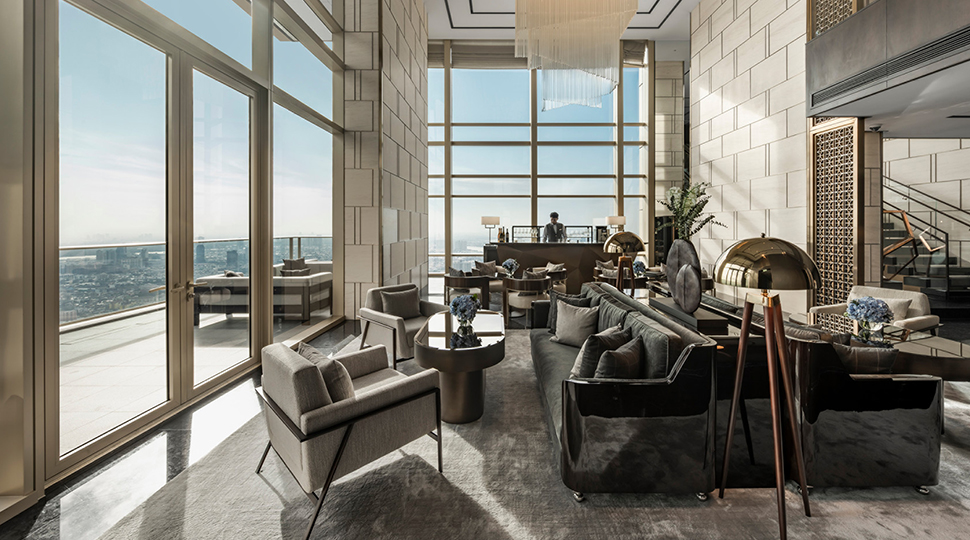 Living room with double-height ceiling, floor-to-ceiling windows and a large chandelier