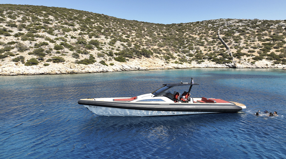 Speedboat anchored in dark blue waters with an island nearby