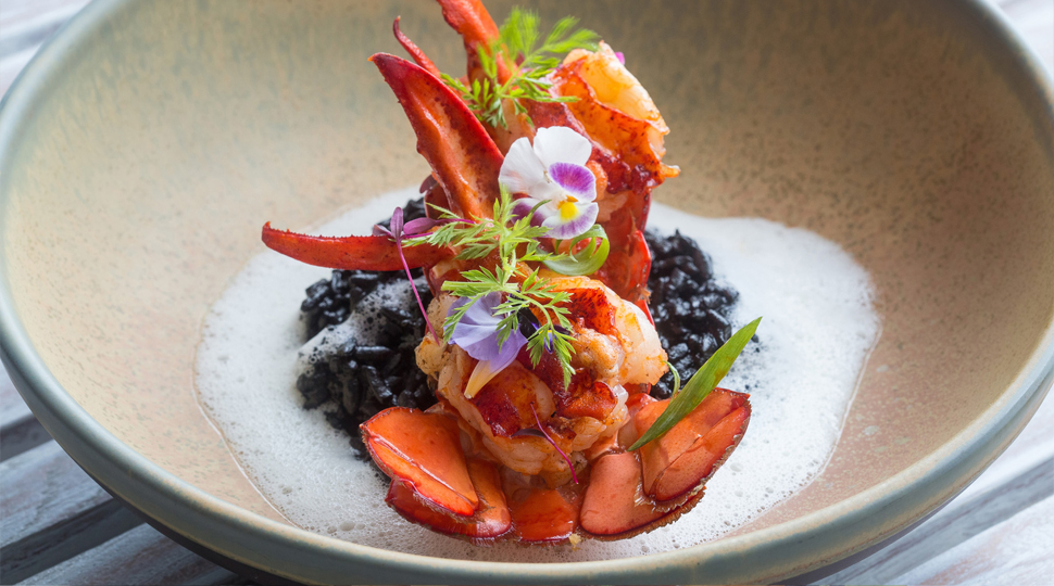 Colourful dish of berries and floral garnish