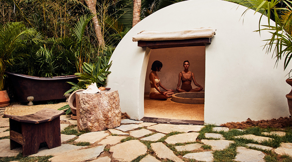 White domed temazcal with two people sitting inside